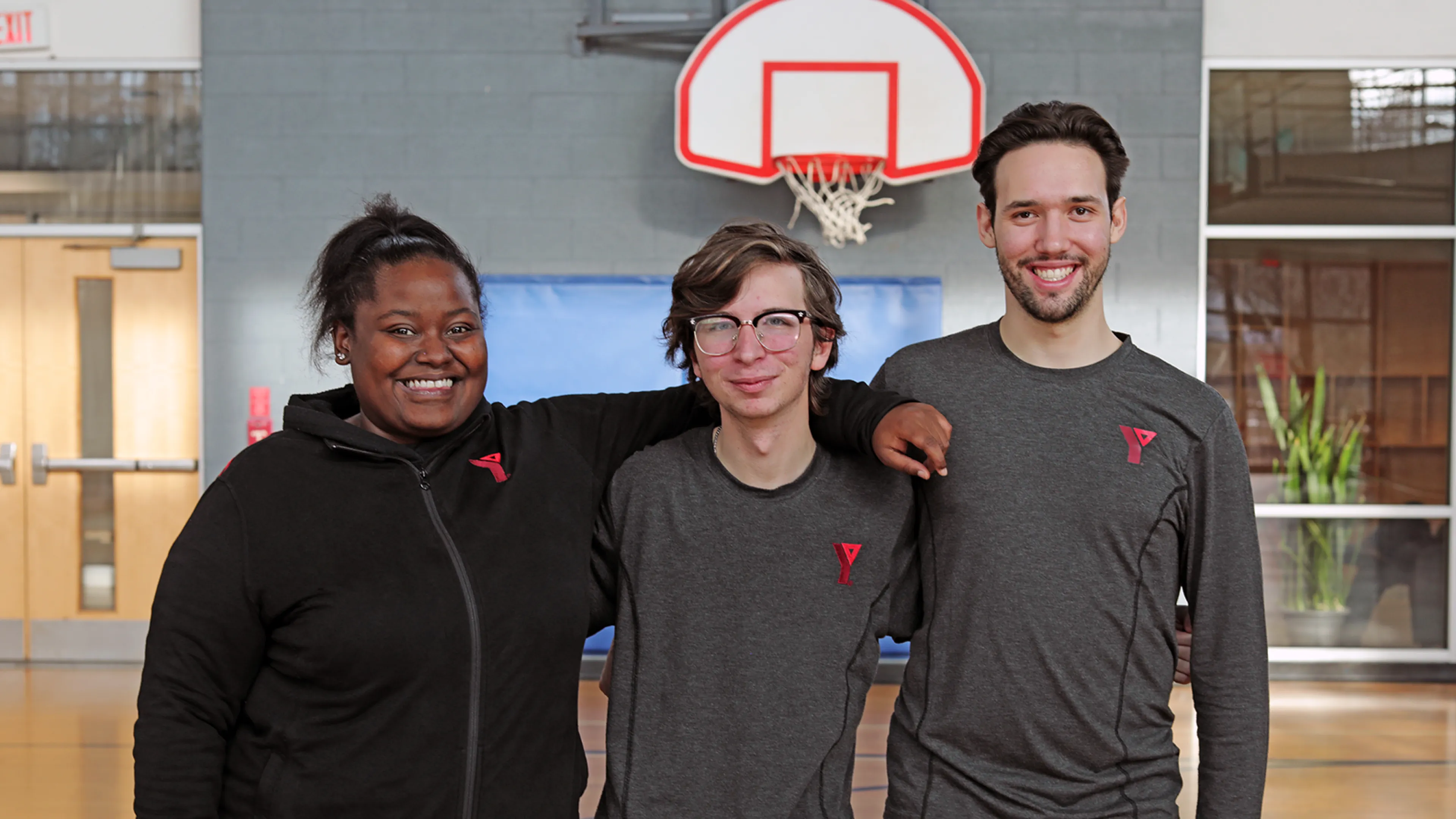 Young YMCA staff posing and smiling in main gym