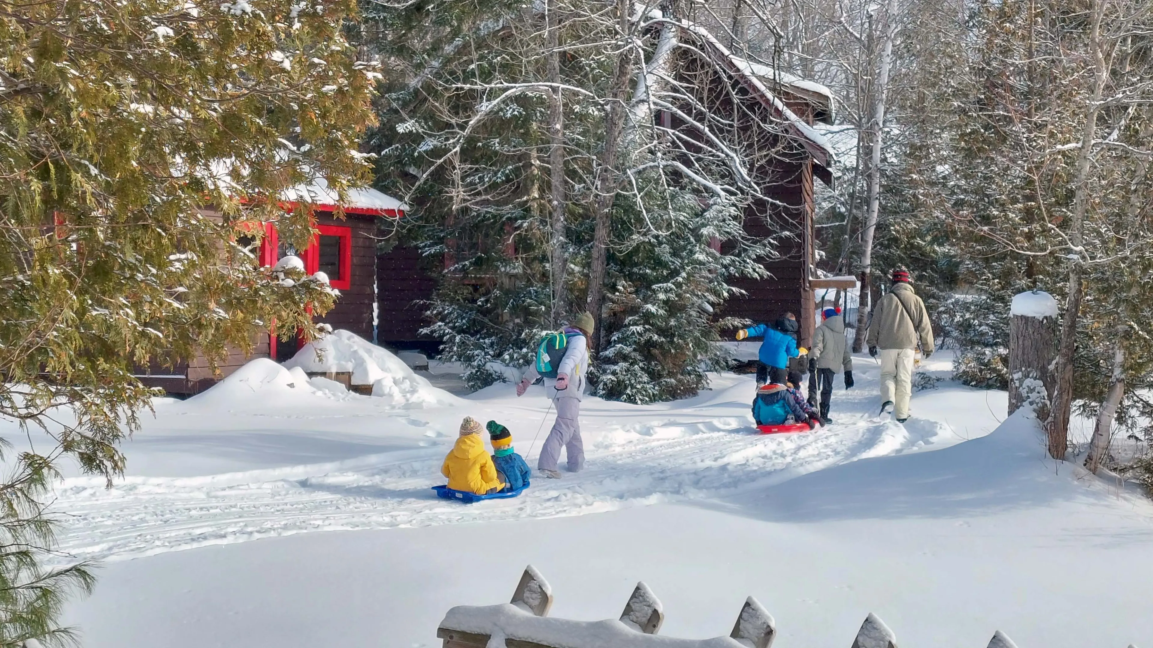Family walking through wintery scene with cabins in background
