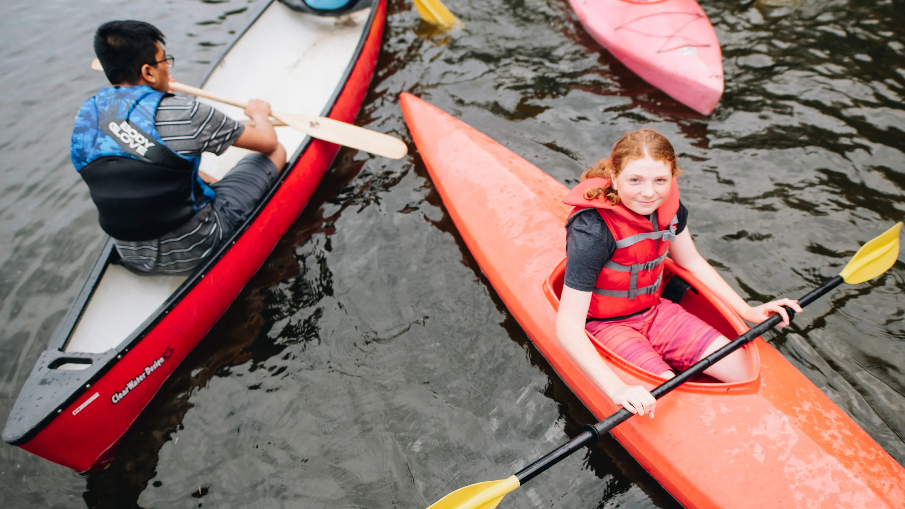 Kids in canoes on the water