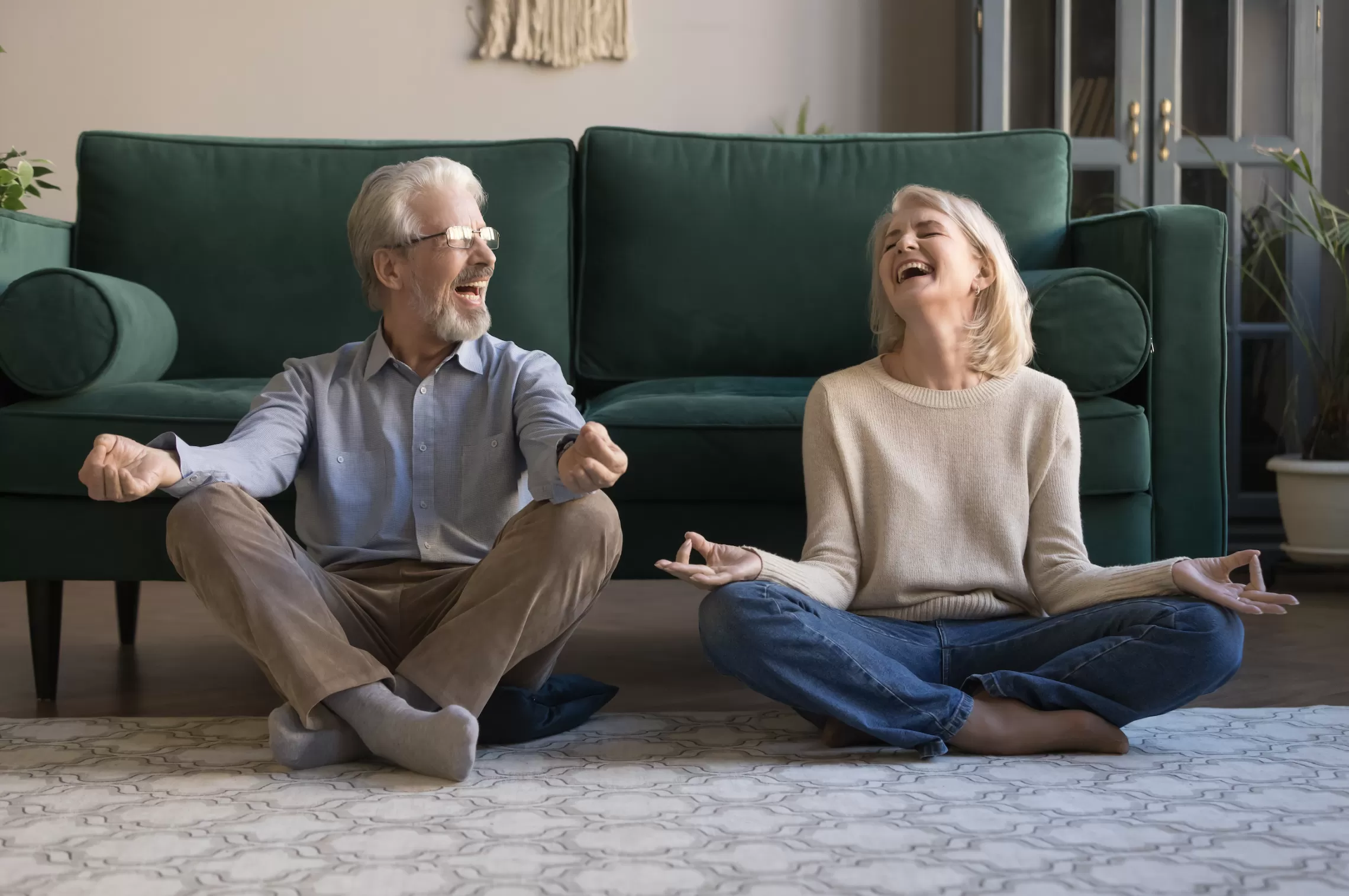 Senior Couple in yoga poses looking at one another and smiling 