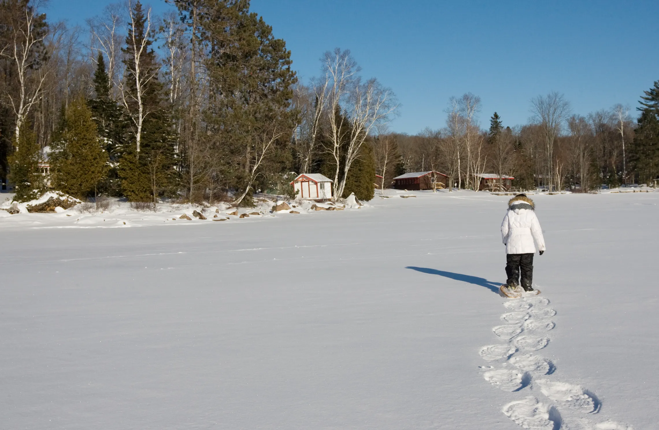 Snowshoer trekking across frozen lake