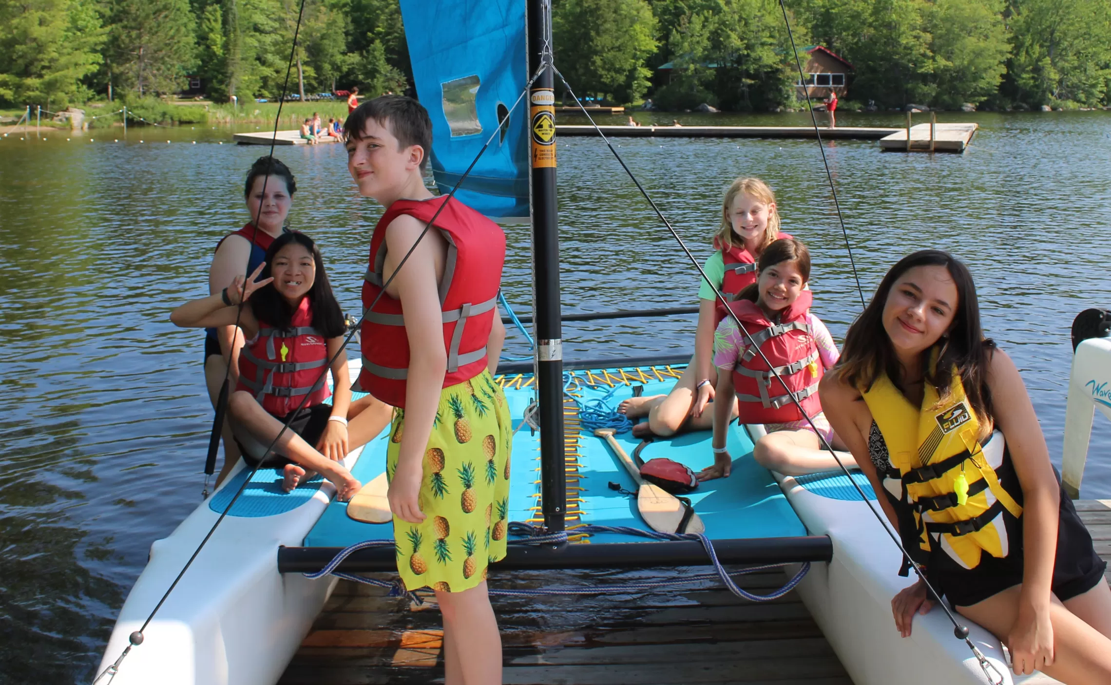 Six young people sitting on a sailboat. 