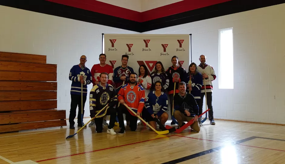 Team photo with hockey sticks in gym