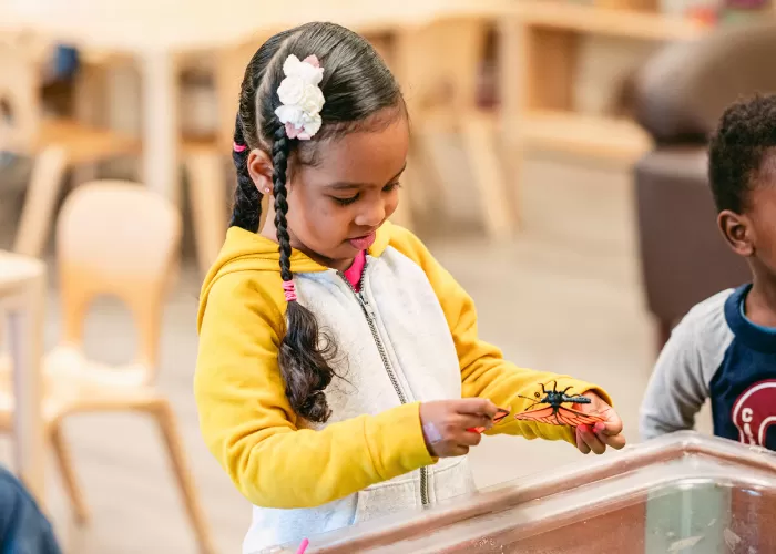 Child playing with a toy butterfly