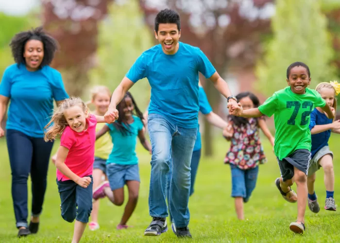 Group of individuals of all ages running and holding hands