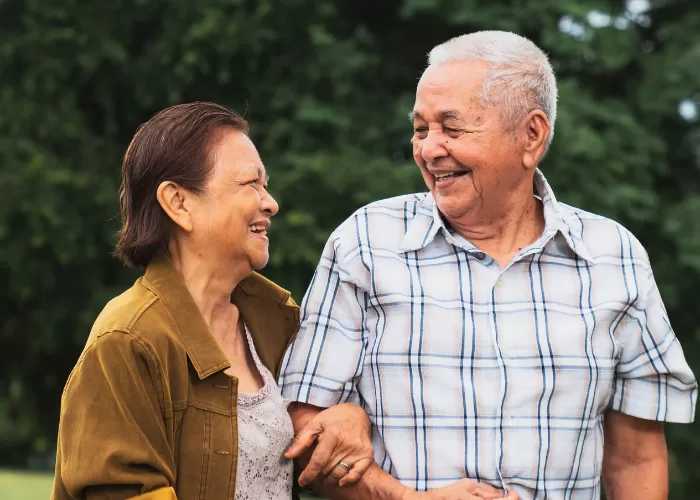 Two older individuals walking together and smiling