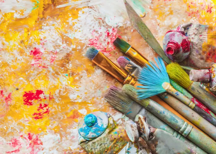 Used paints, paintbrushes and canvas