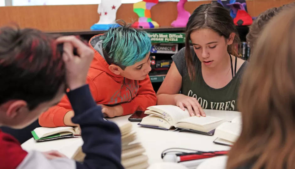 young people reading at table