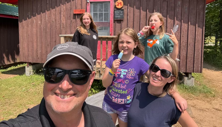 Mom, dad, and three girls take a selfie in front of cabin 29 at Wanakita