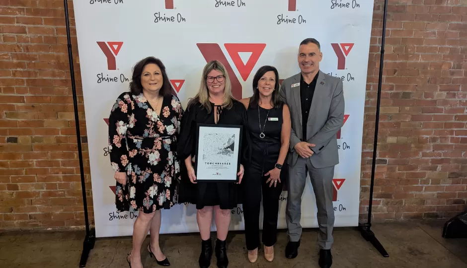 4 people in front of a YMCA banner