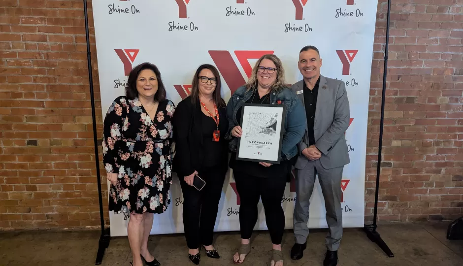 4 people in front of a YMCA banner