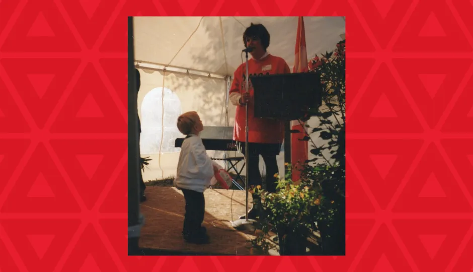 young boy looks up at womangiving speech at microphone