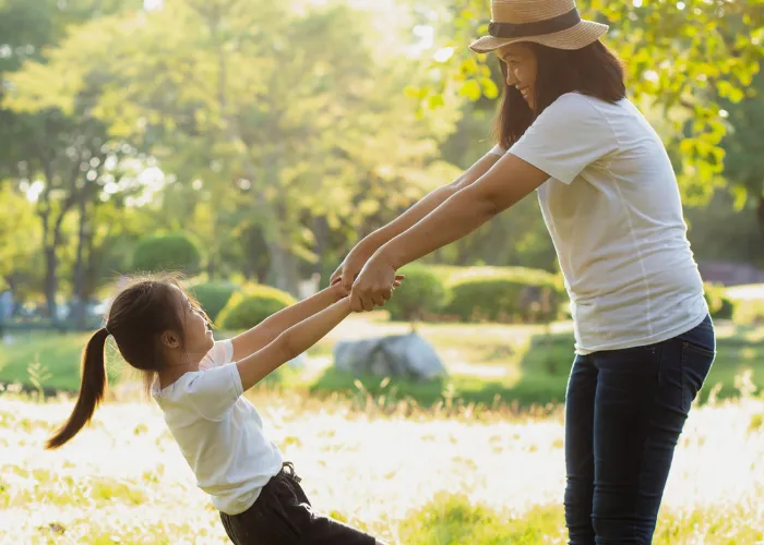 Mother and Daughter holding hands at a park
