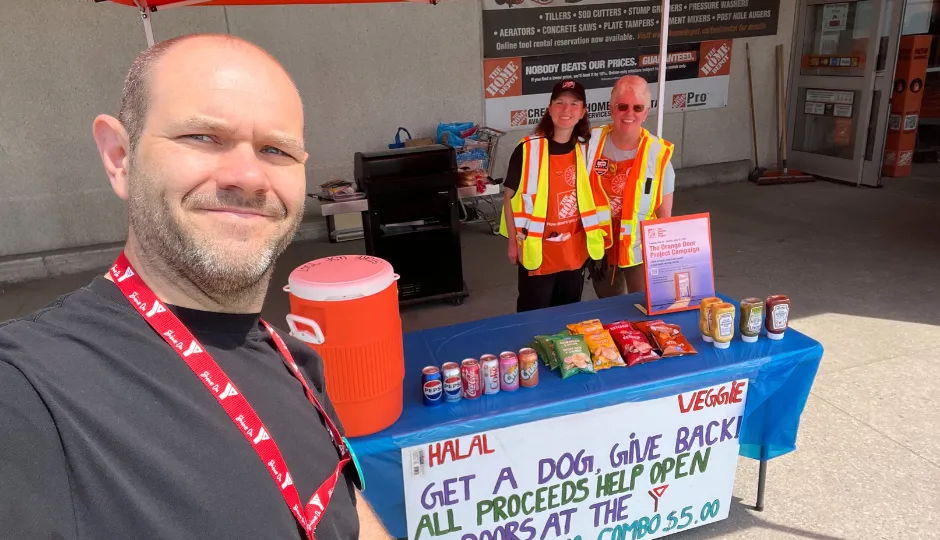 Man takes selfie with home depot staff selling food and drinks