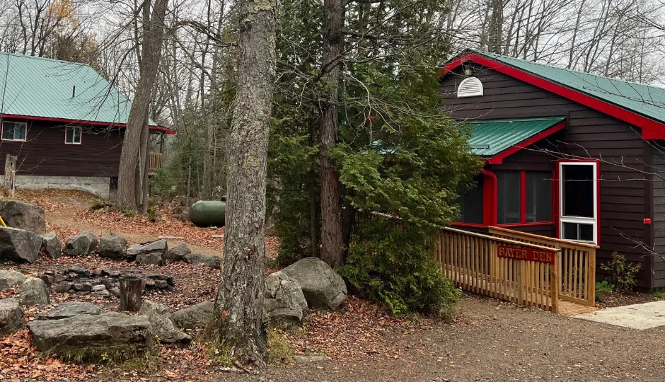 brown cabins with forest green steel roofs and red trim