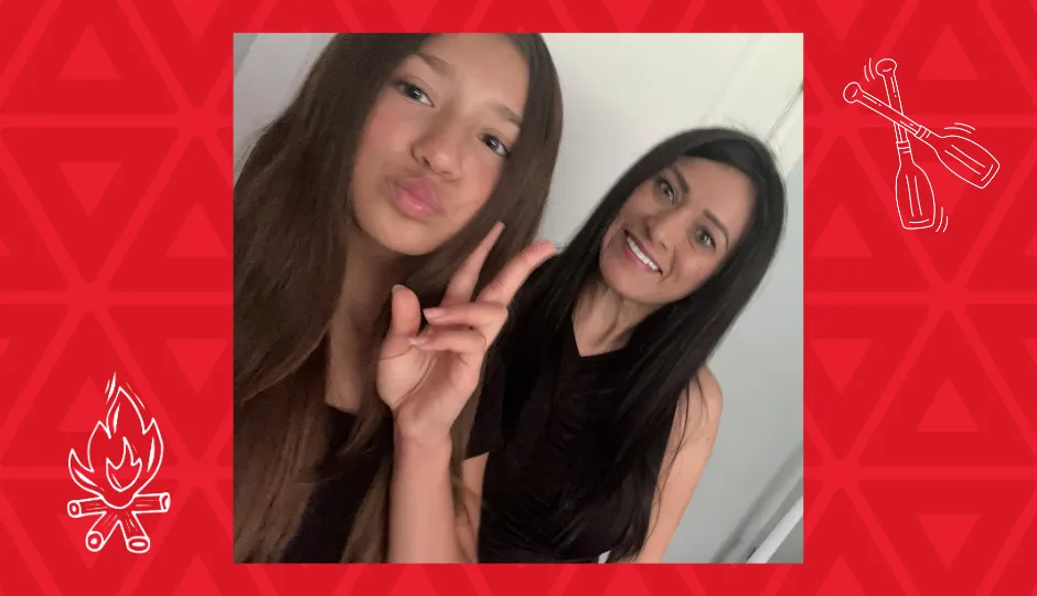 Girl holding peace sign with mother smiling