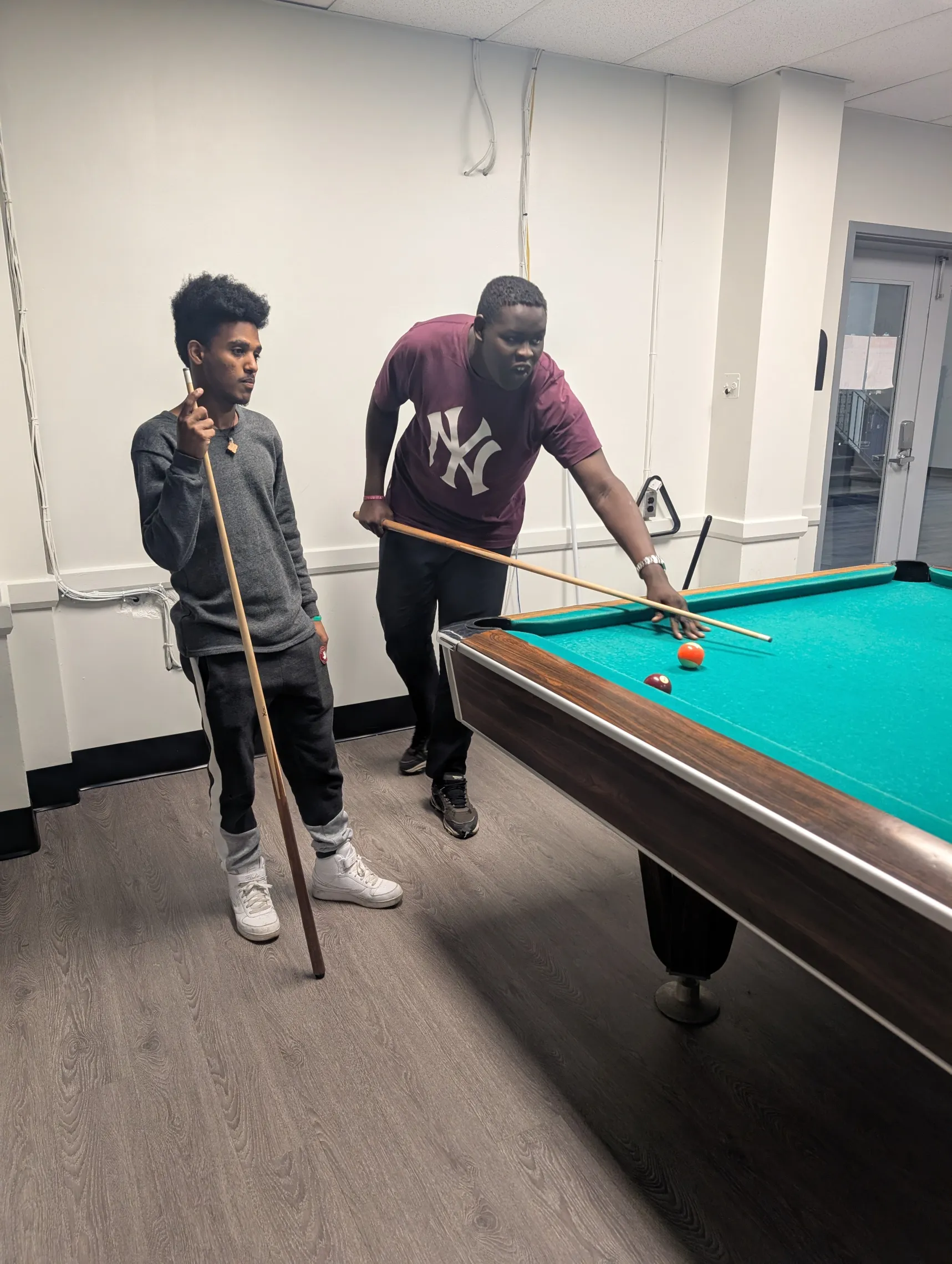 Daniel and Mohsen playing billiards Newcomer youth Centre