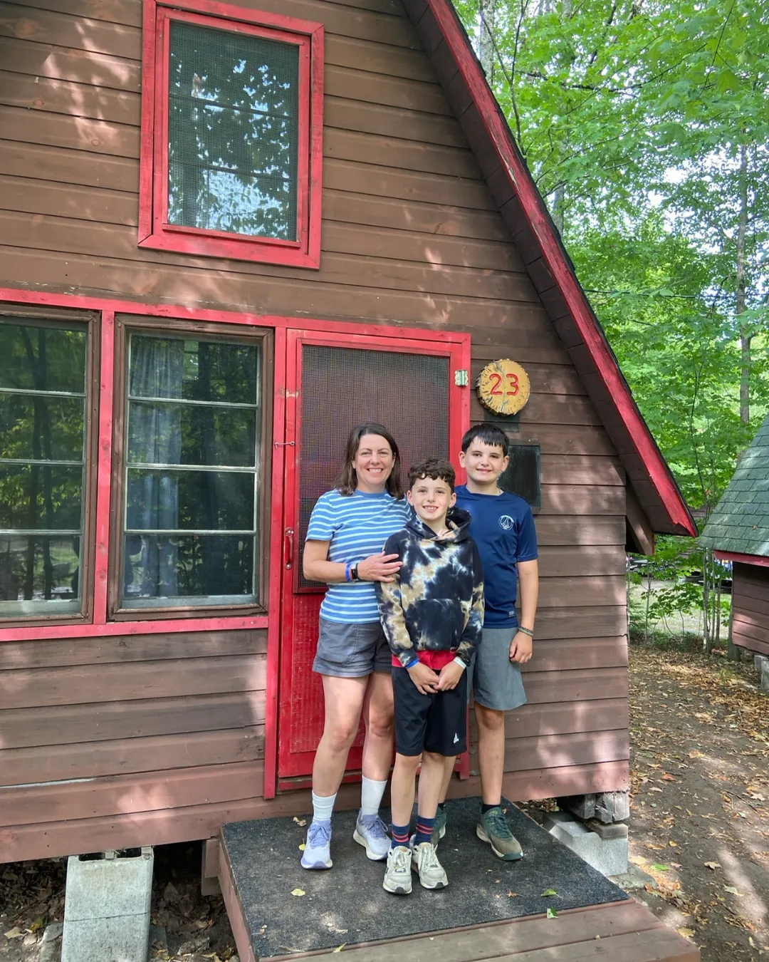 Julian and family in front of a-frame cabin