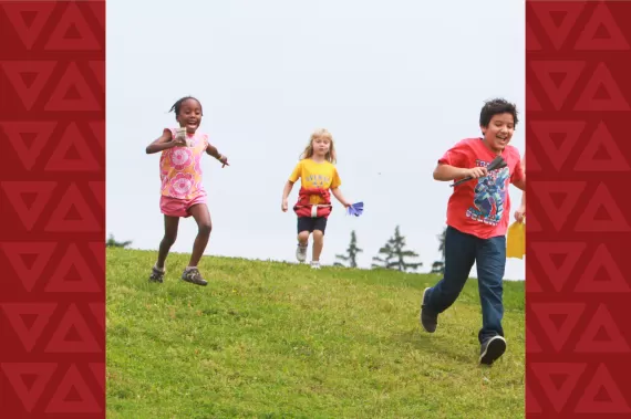 Three children running down a hill