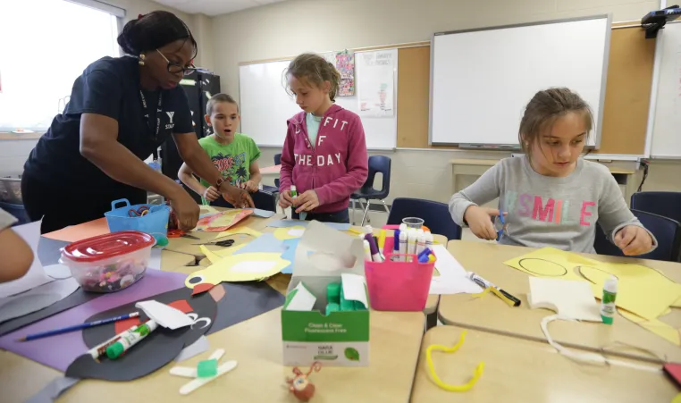 Educator with children crafting at table