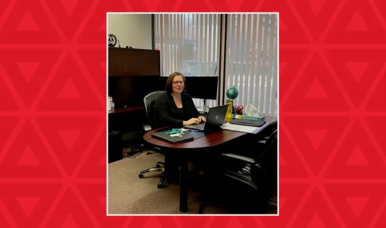 Woman sits in her office working on a laptop