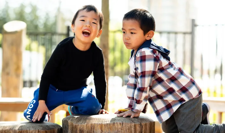 Two children playing in the park and smiling