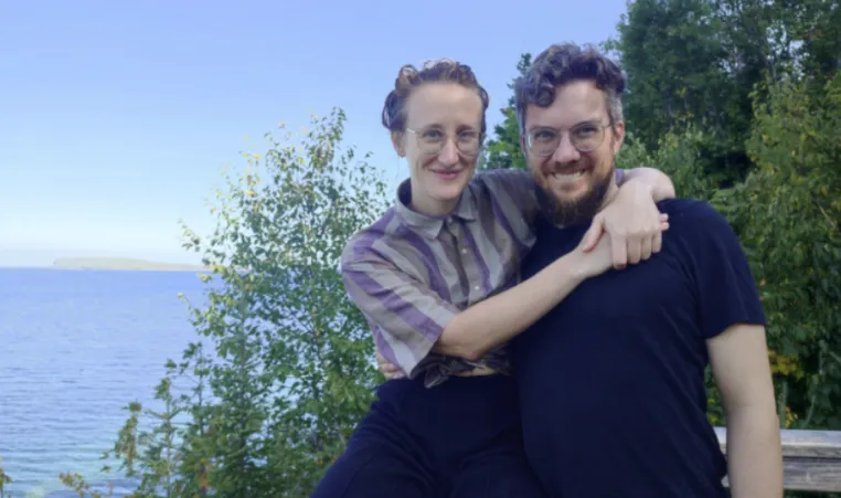 Man and woman take photo with lake in background