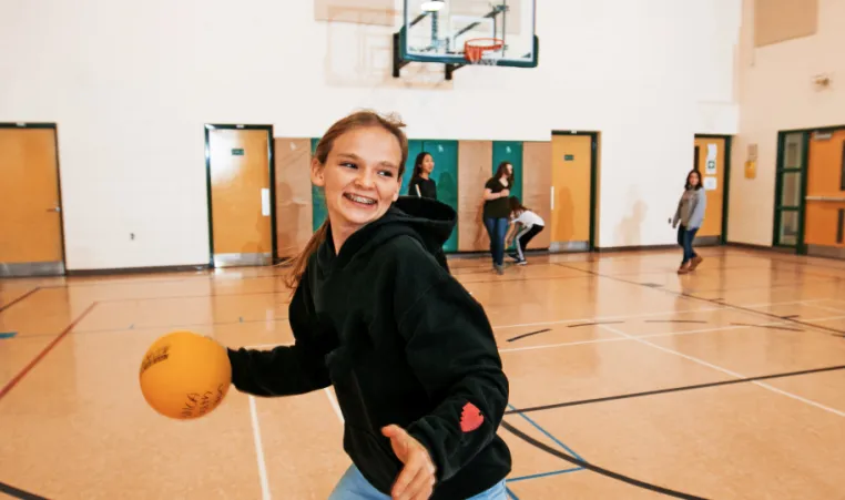 preteen girl dribbles basketball