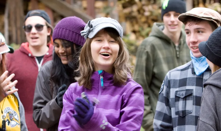 pre teen girl smiles asnd claps to camp song