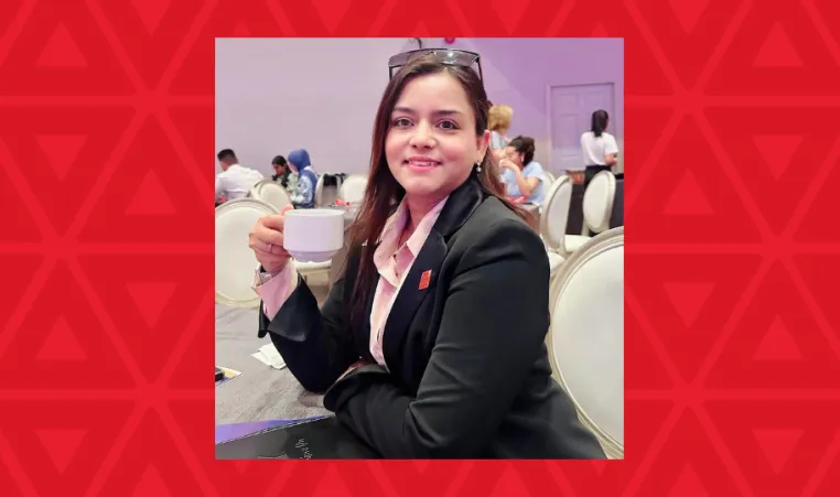 woman holding coffee cup sitting at table