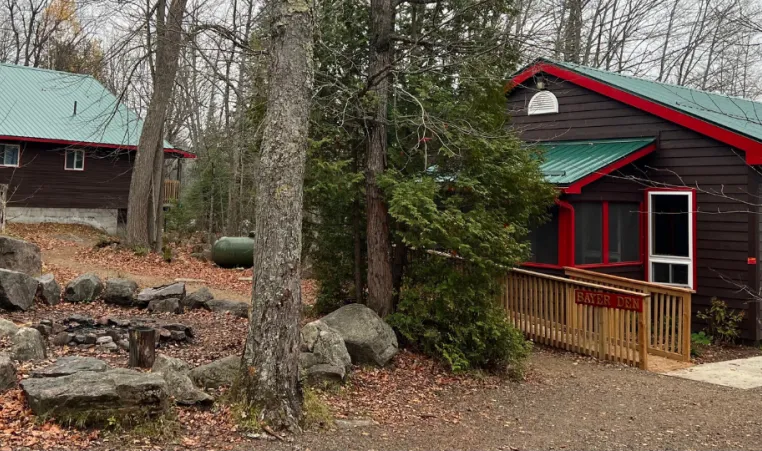 brown cabins with forest green steel roofs and red trim