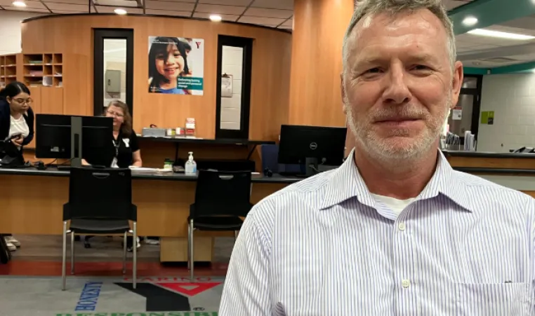  Smiling Older man sits in front of membership desk