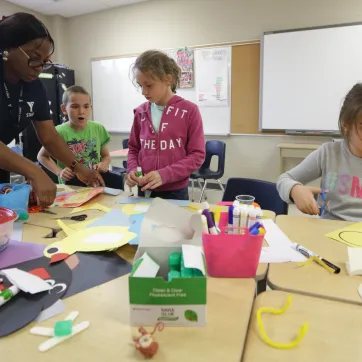 Educator with children crafting at table