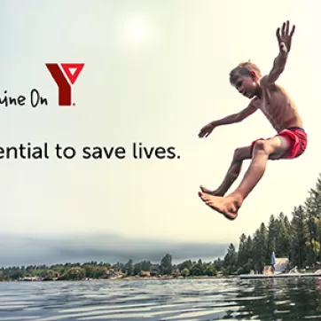 children jumping into lake from dock in summer YMCA Shine On Logo, slogan 'Igniting Potential to Save Lives'