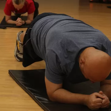 Man does plank during fitness class