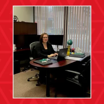 Woman sits in her office working on a laptop