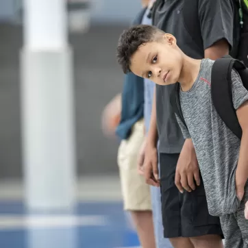 young boy leaning out of line 