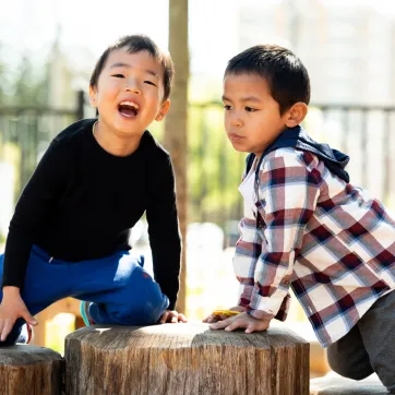 Two children playing in the park and smiling
