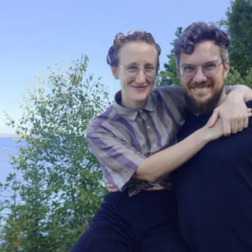 Man and woman take photo with lake in background