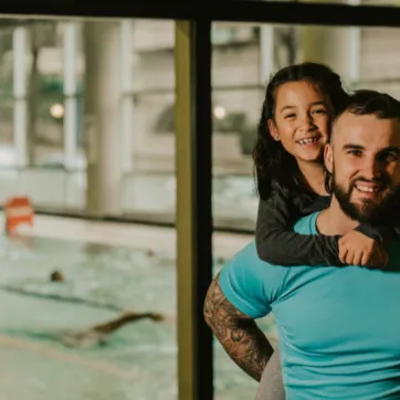 fatherg gives daughterpiggy back infront of pool