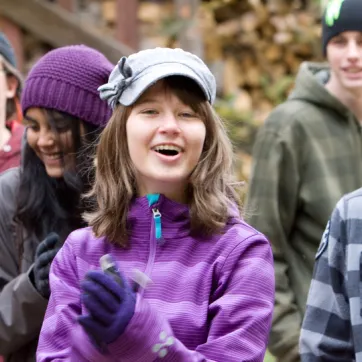 pre teen girl smiles asnd claps to camp song