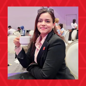 woman holding coffee cup sitting at table