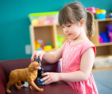 Female preschool child playing with animal figures