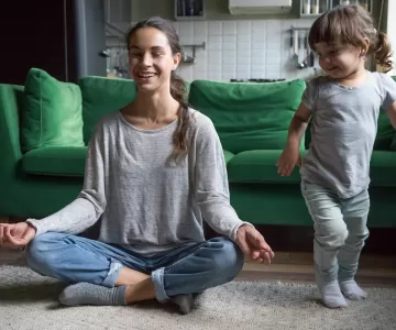Female woman in yoga pose on living room floor with daughter
