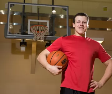Young man in red shirt holding basektball