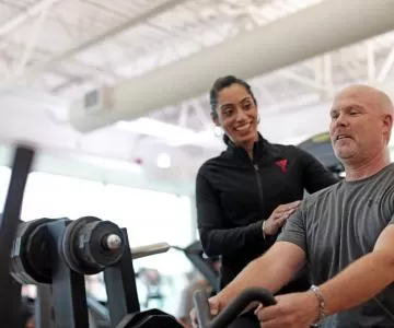 Staff Assisting Member During Strength Training