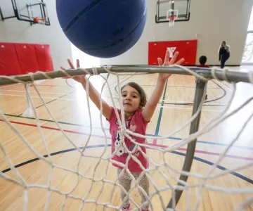 Female child throwing basketball into net