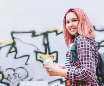 Youth walking in front of graffiti wall