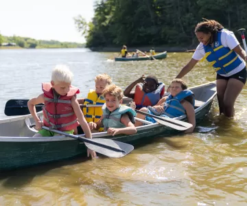 day camp children in a canoe smiling on christie lake