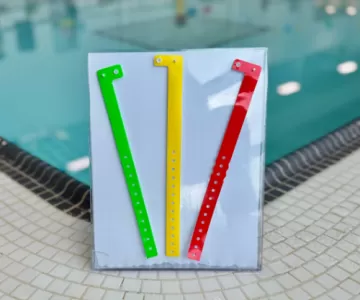 Green, Yellow and Red wristbands in front of a pool